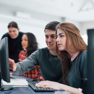 Giving advice. Group of young people in casual clothes working in the modern office