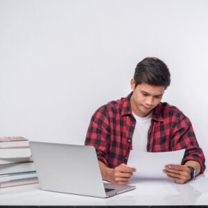 A man using a laptop in the office and doing a document analysis